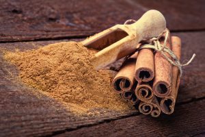 Cinnamon sticks and cinnamon powder on wood floor