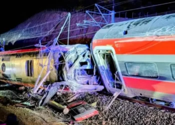 Due treni ad alta velocità deragliati e gravemente danneggiati dopo un violento scontro notturno in Andalusia, Spagna, con vagoni accartocciati e soccorritori sul luogo dell’incidente.